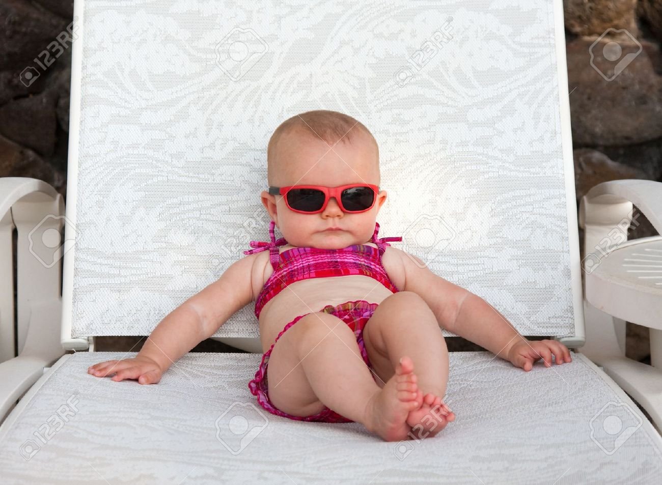 bebe jugando en la playa con traje de bano