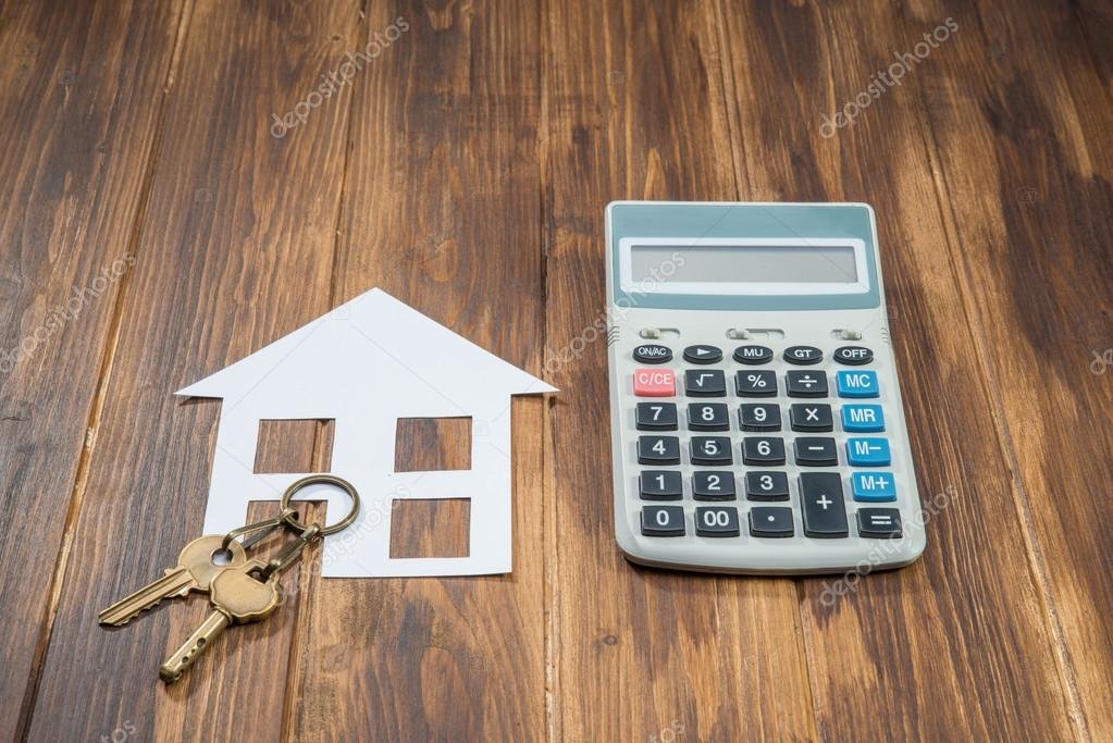casa con llave y calculadora financiera