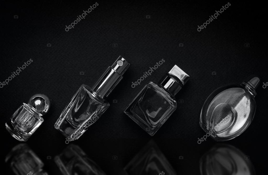 frascos de perfume elegantes en fondo oscuro