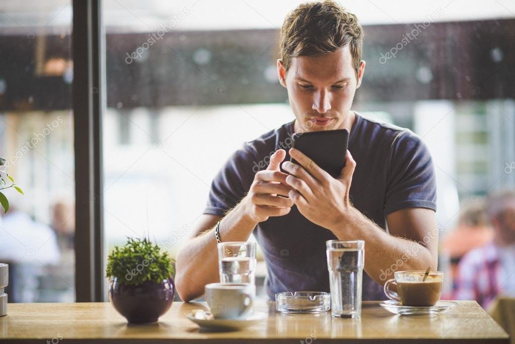 persona usando un celular en un cafe