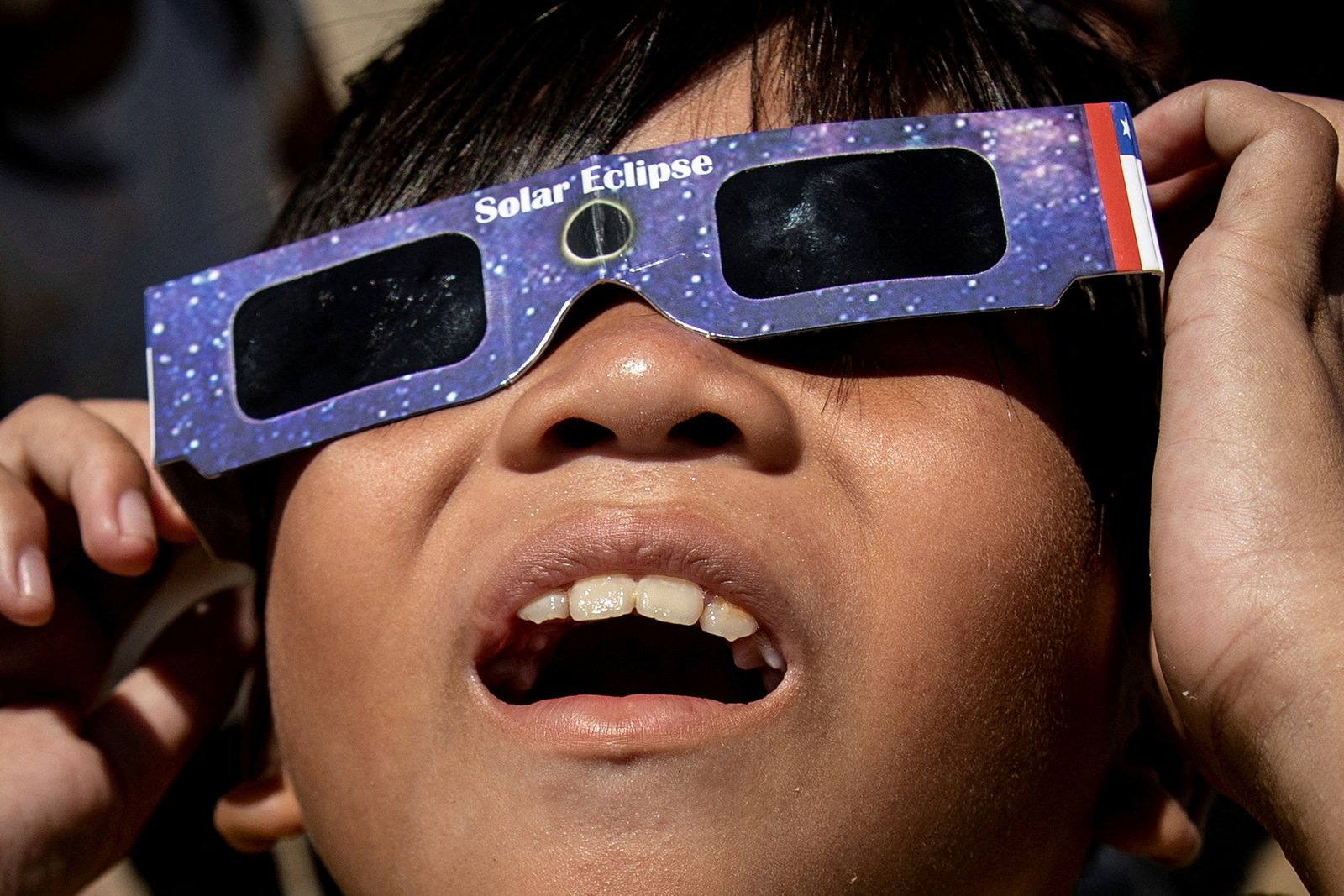 personas mirando un eclipse solar con lentes