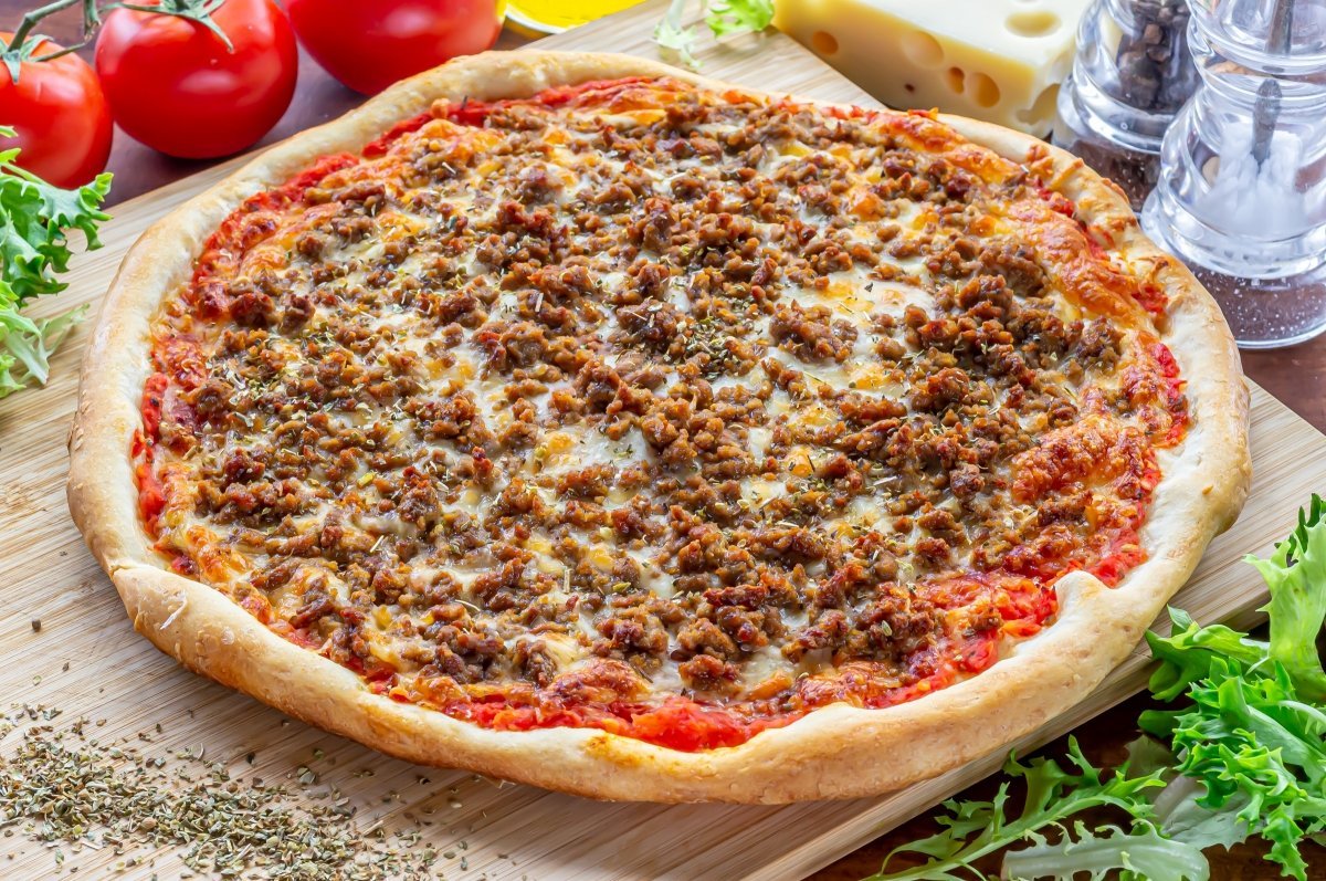 variedad de carnes sobre una pizza deliciosa